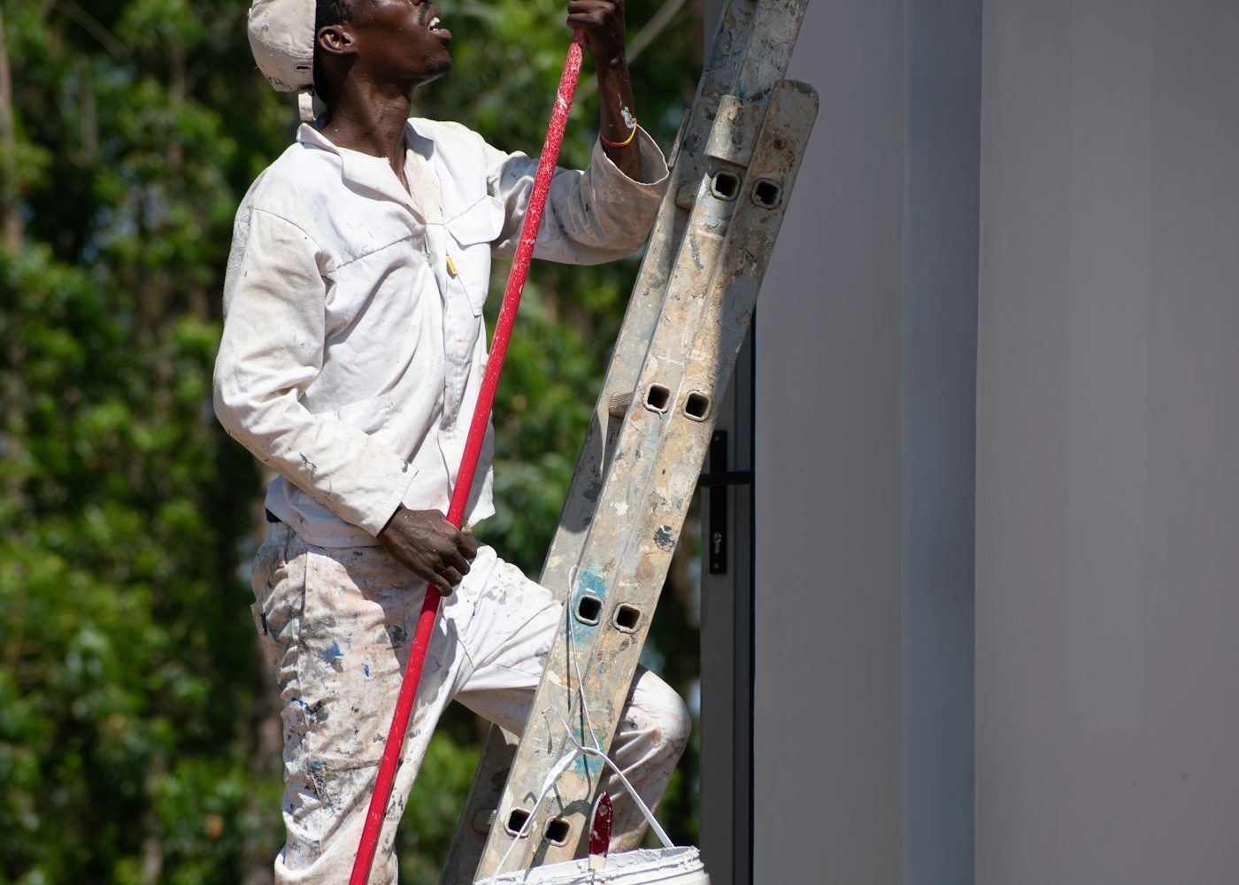 Painter cutting in along a wall from a ladder