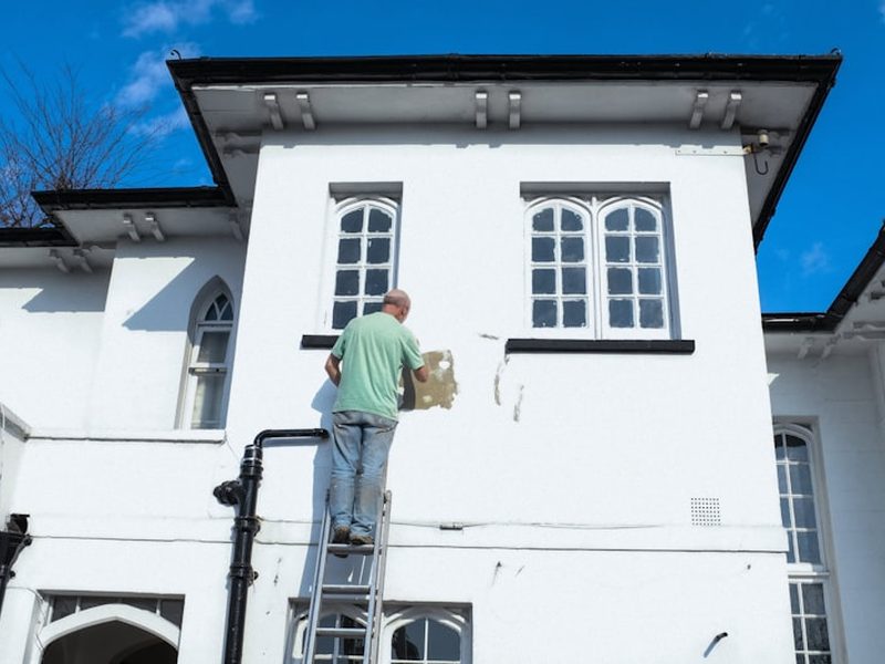Painter working on a rendered exterior wall